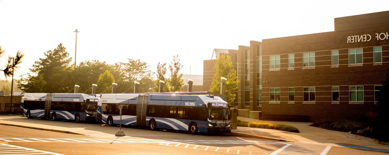 GVSU Kirkhof Center with parked rapid buses at sunrise.